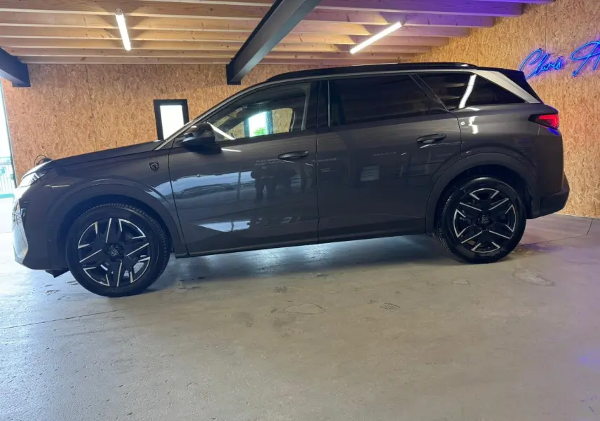 Peugeot 5008 1.2 Hybrid 136 GT gris, vue profil côté gauche, avec jantes alliage noires et toit noir contrasté.