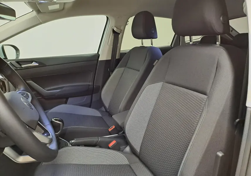 Vue intérieure côté gauche du Volkswagen Taigo 2025, sièges avant en tissu gris avec détails texturés.