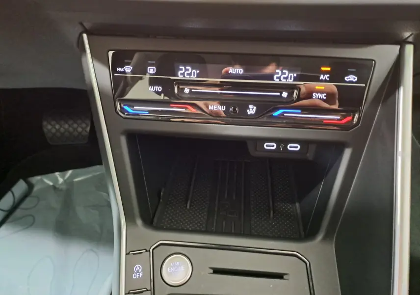 Gros plan sur la console centrale du Volkswagen Taigo 2025, climatisation bi-zone tactile et ports USB visibles.