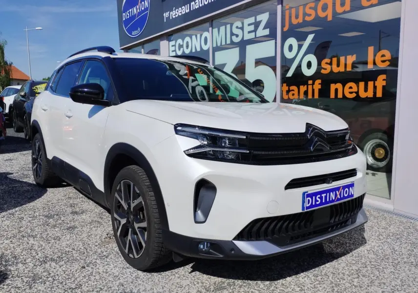 Vue 3/4 avant droit d'un Citroën C5 Aircross blanc nacré avec toit noir et calandre noire brillante.