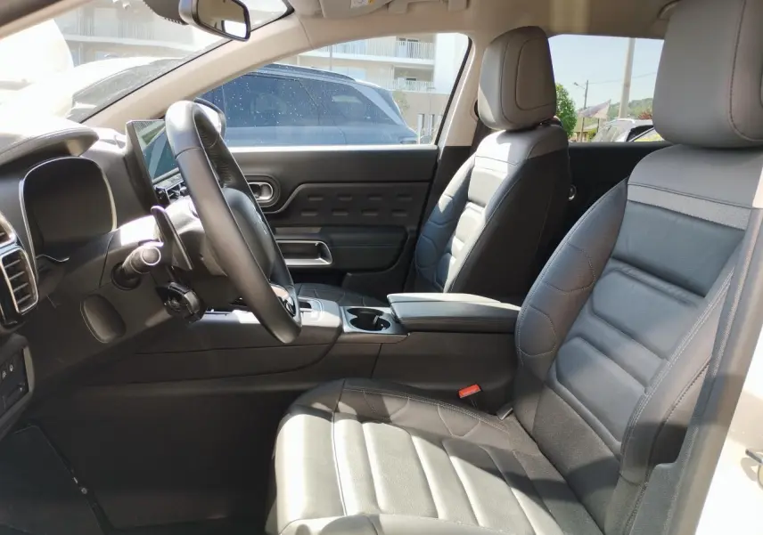 Vue intérieure côté conducteur du Citroën C5 Aircross 2022, sièges cuir noir et console centrale avec accoudoir.