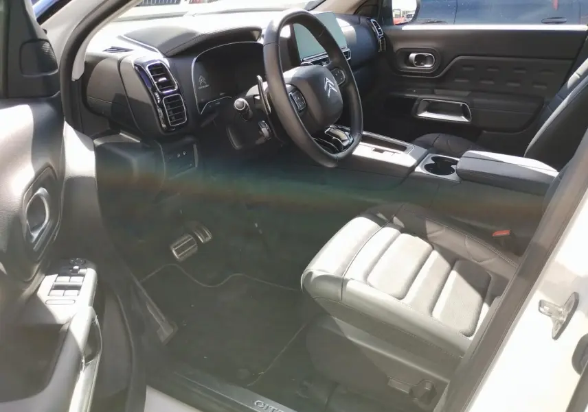 Vue intérieure côté conducteur du Citroën C5 Aircross blanc nacré, volant cuir et sièges Advanced Comfort noirs.