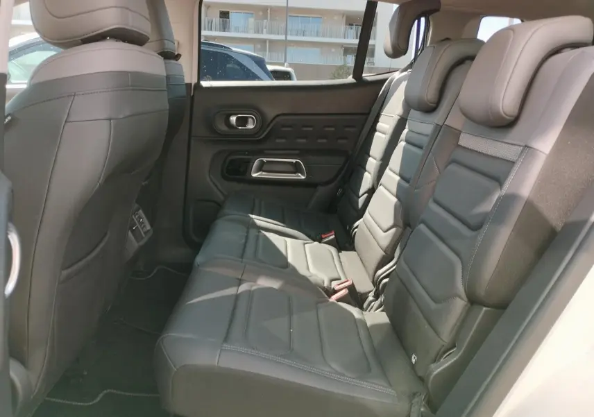 Vue latérale droite de l'habitacle arrière du Citroën C5 Aircross 2022 avec sièges cuir noir et appuie-têtes intégrés.