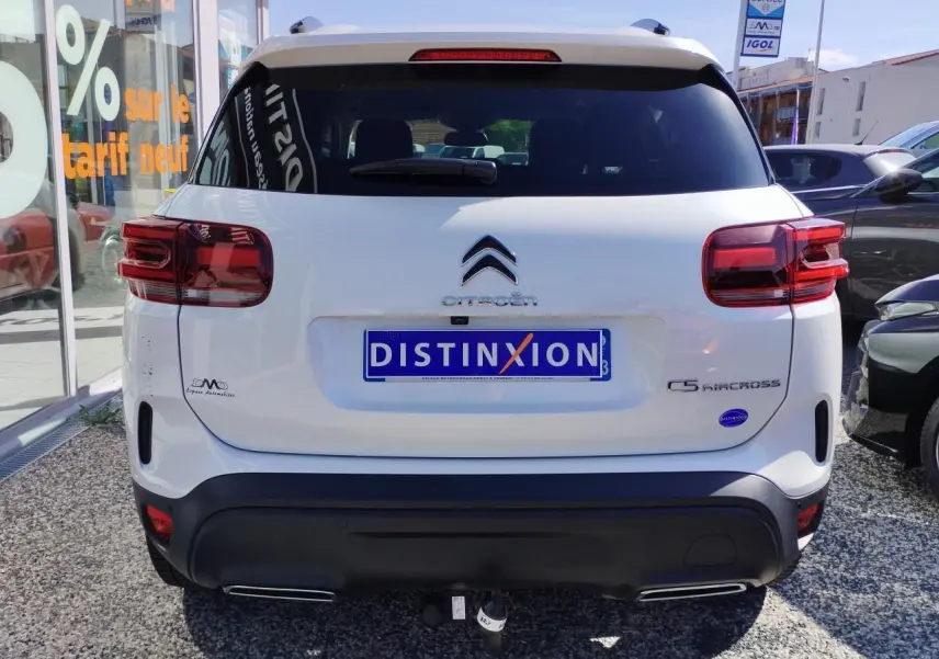 Vue arrière d'un Citroën C5 Aircross blanc nacré avec toit noir, attelage col de cygne et feux arrière LED 3D.