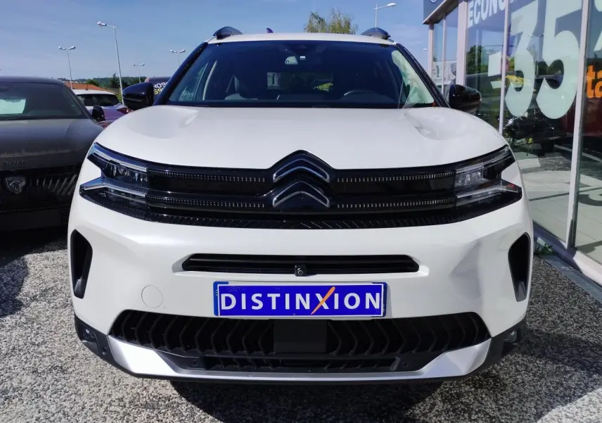 Vue avant d'un Citroën C5 Aircross blanc nacré avec calandre noire brillante et logo double chevron.
