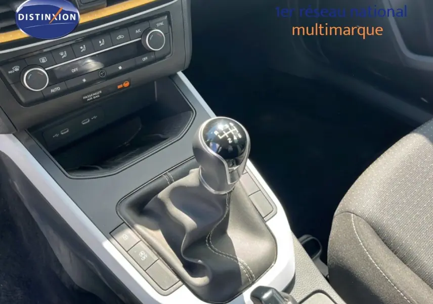 Gros plan sur la console centrale du SEAT Arona 2025 avec levier de vitesse manuel et commandes de climatisation.