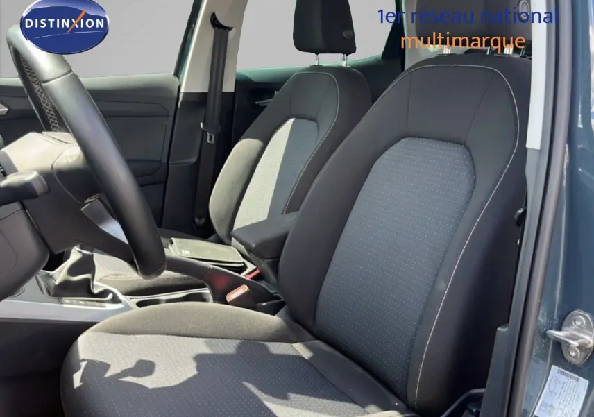 Vue intérieure côté gauche montrant les sièges avant en tissu gris noir d'une SEAT Arona Bleu Fjord 2025.