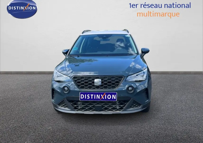 Vue frontale d'un SEAT Arona bleu Fjord avec toit blanc, calandre noire et phares LED allumés.