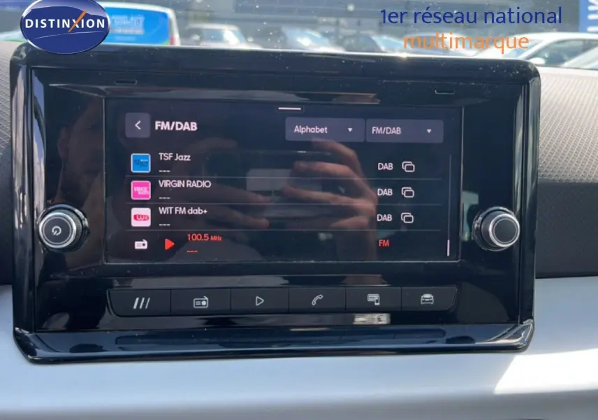 Écran tactile central du tableau de bord du SEAT Arona 2025, affichant les options radio FM/DAB avec finition intérieure gris noir.