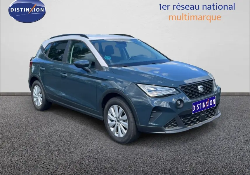 SEAT Arona bleu Fjord avec toit blanc, vue 3/4 avant droit, mettant en valeur ses lignes modernes et ses jantes argentées.