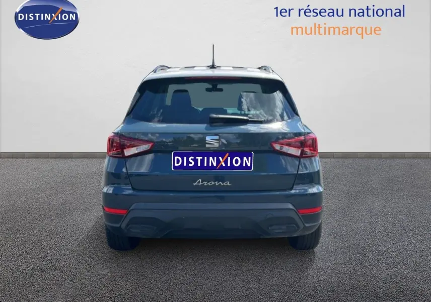 Vue arrière d’un SEAT Arona bleu Fjord avec toit blanc, version Style Special Edition 2025, sur fond gris neutre.