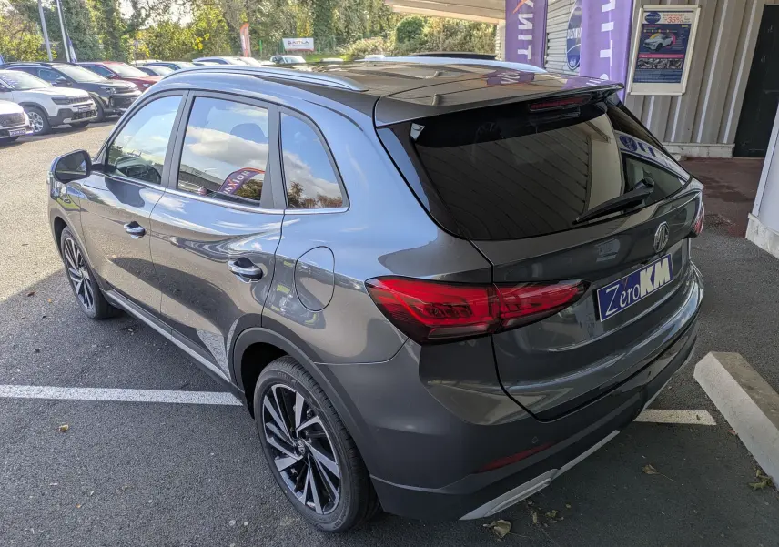 Vue 3/4 arrière droite du MG ZS 2026 gris Candem avec toit panoramique et jantes alliage 18 pouces.