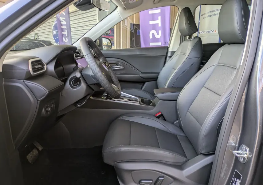 Vue intérieure centrée sur le volant en cuir perforé et la console avec écran tactile éteint du MG Motor ZS 2026 Candem Grey.