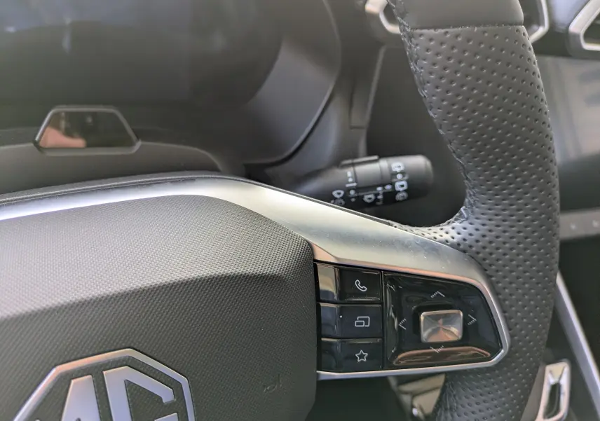 Gros plan sur le volant en cuir perforé noir du MG ZS 2026, avec commandes intégrées et commodo d’éclairage visible.