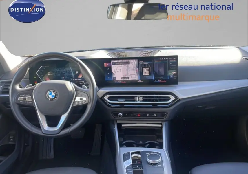 Vue intérieure avant de la BMW Série 3 Touring F31 noire, montrant le volant multifonction et l'écran tactile large du tableau de bord.