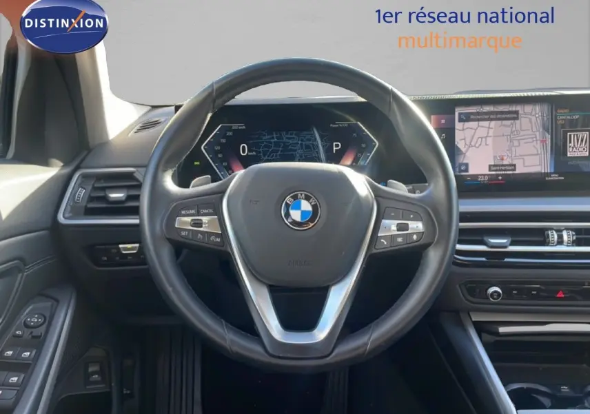 Vue intérieure centrée sur le volant cuir noir et le tableau de bord digital de la BMW Série 3 Touring F31 316d.