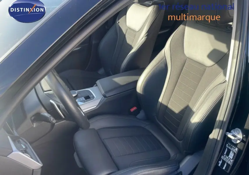 Vue intérieure côté conducteur d'une BMW Série 3 Touring F31 noire, sièges en cuir noir et console centrale moderne.