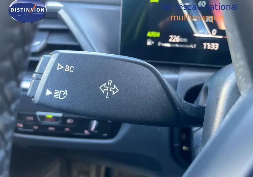 Gros plan sur la commande de clignotant gauche dans l’habitacle noir d’une BMW Série 3 Touring F31 316d 2022.