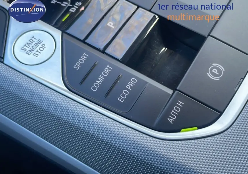 Gros plan sur la console centrale noire de la BMW Série 3 Touring F31, avec boutons de modes de conduite et démarrage.