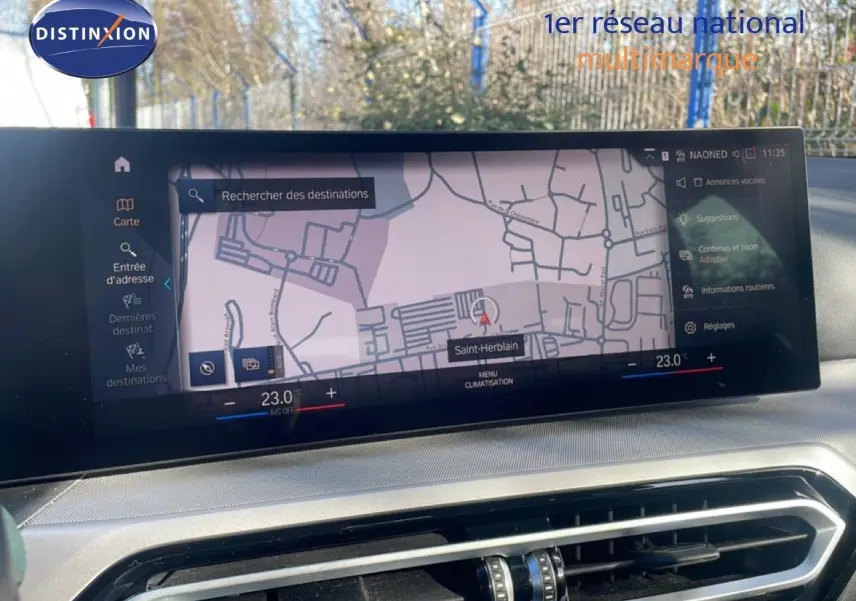 Vue rapprochée de l'écran tactile de navigation et climatisation dans une BMW Série 3 Touring F31 noire, affichant une carte.