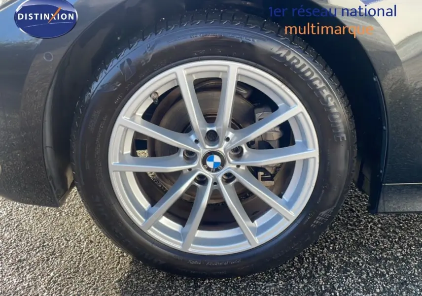 Gros plan sur la roue avant gauche d’une BMW Série 3 Touring F31 noire, avec jante alliage argent et pneu Bridgestone.