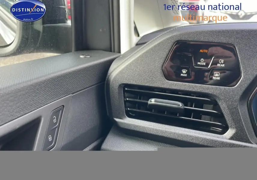 Détail intérieur côté gauche du Volkswagen Caddy 2025 gris indien, montrant la commande des vitres et la sortie d'air du tableau de bord.