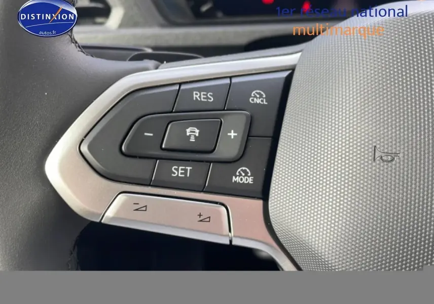 Gros plan sur les commandes du volant cuir multifonction du Volkswagen Caddy gris indien, avec régulateur adaptatif.