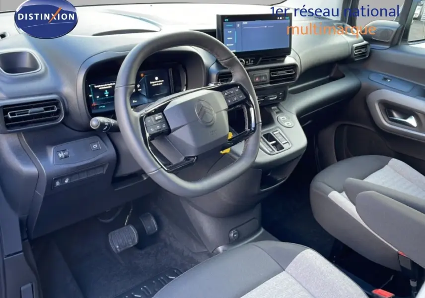 Vue intérieure côté conducteur du Citroën Berlingo Multispace blanc glacier, avec tableau de bord numérique et volant multifonction.