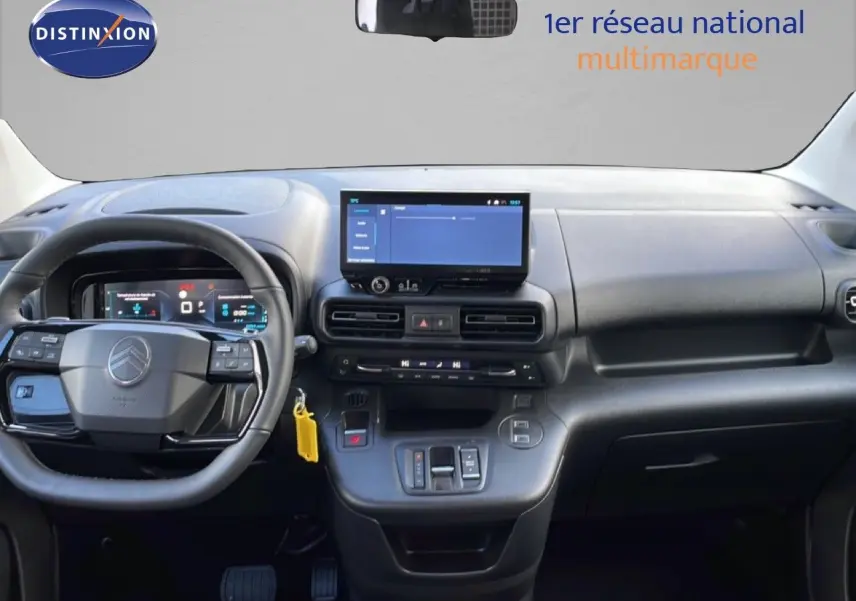 Vue intérieure frontale du tableau de bord noir du Citroën Berlingo Multispace blanc avec écran tactile et volant multifonction.