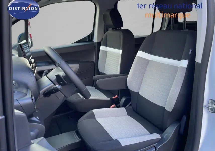 Vue intérieure côté gauche du Citroën Berlingo blanc glacier, mettant en valeur les sièges tissu bicolores gris et noir.