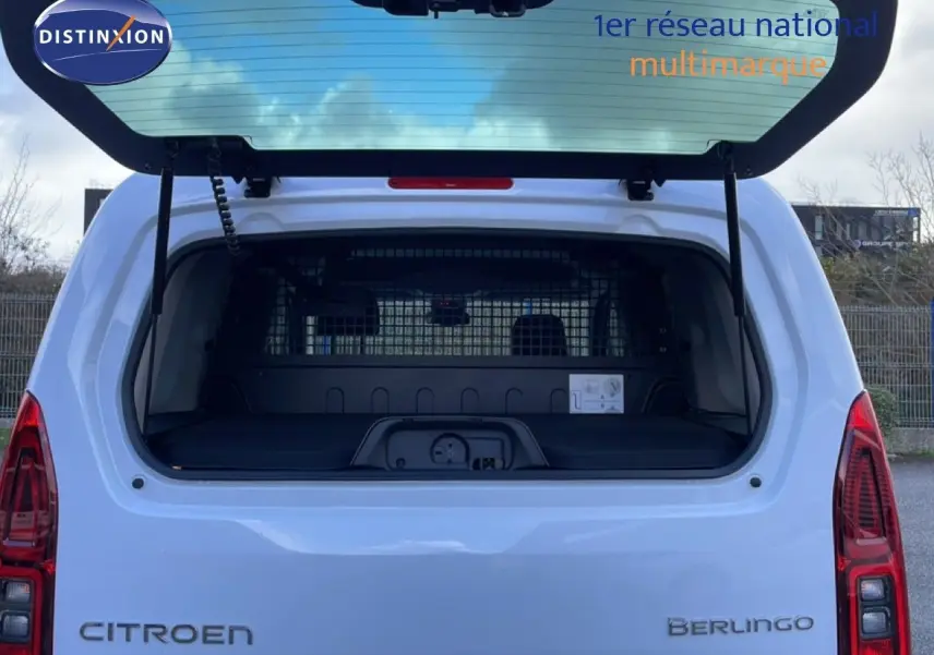 Vue arrière du Citroën Berlingo blanc glacier avec hayon ouvert, montrant le coffre spacieux et la grille de séparation.