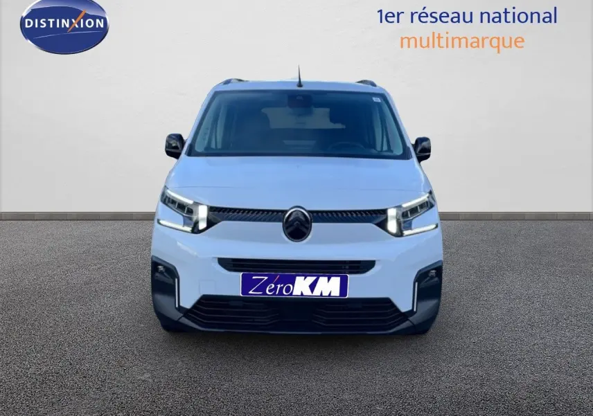 Vue frontale d'un Citroën Berlingo Multispace blanc glacier avec feux LED allumés sur fond neutre.