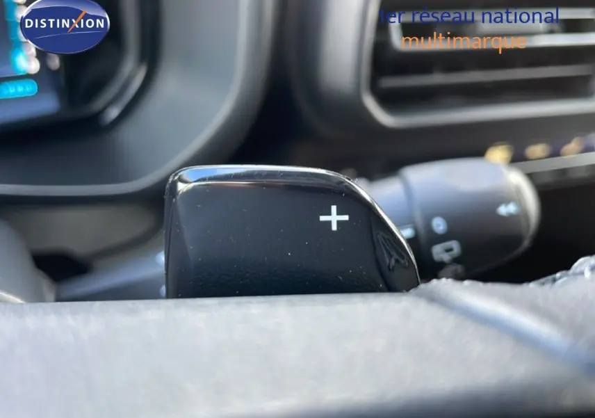 Gros plan sur la palette de changement de vitesse "+" côté droit du volant dans un Citroën Berlingo blanc glacier.