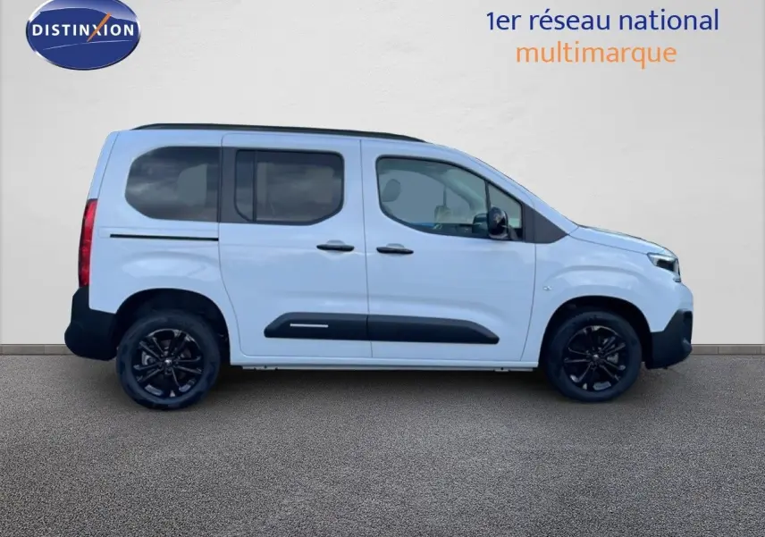Profil côté gauche d'un Citroën Berlingo Multispace blanc glacier avec jantes noires et protections latérales noires.