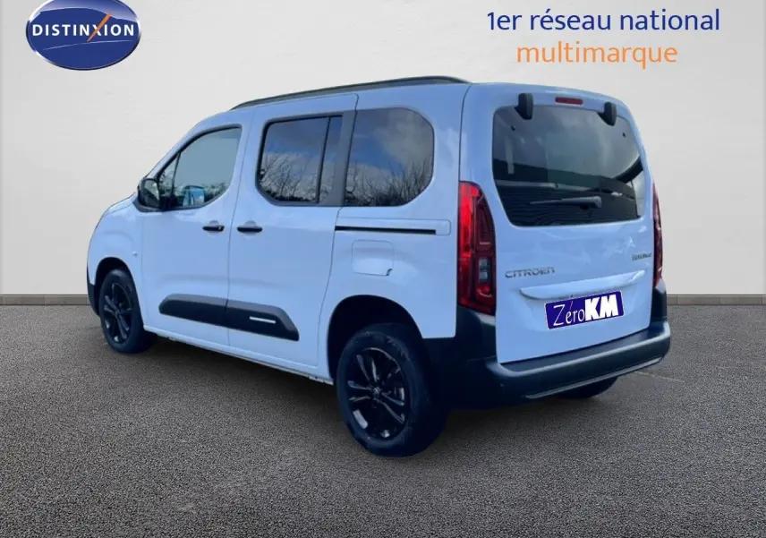 Vue 3/4 arrière droite d'un Citroën Berlingo Multispace blanc glacier avec jantes noires et vitres teintées.