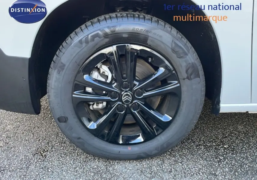 Gros plan sur la roue avant droite noire brillante du Citroën Berlingo blanc glacier.