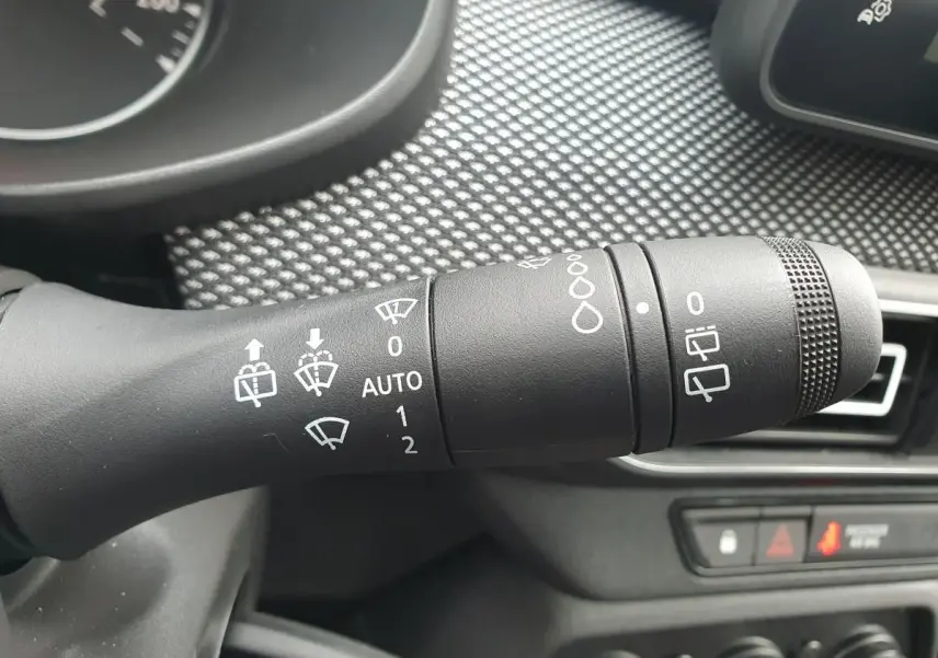 Gros plan sur la commande des essuie-glaces du DACIA Sandero 2025, intérieur noir avec tableau de bord texturé.