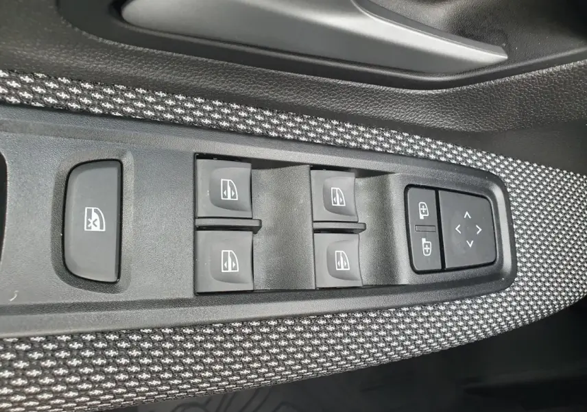 Panneau de commandes des vitres électriques et réglages des rétroviseurs sur la porte côté conducteur d’une Dacia Sandero.