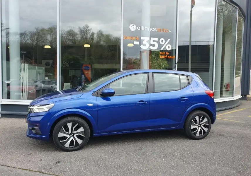 Profil côté gauche de la Dacia Sandero 2025 bleu Iron avec enjoliveurs noirs et signature lumineuse LED visible.