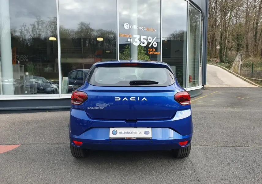 Vue arrière d'une Dacia Sandero 2025 bleu Iron, avec feux arrière rouges et logo DACIA bien visible.