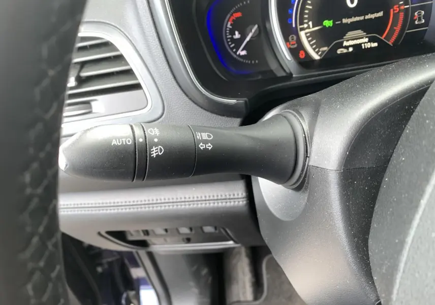 Gros plan sur la manette de commande des phares et clignotants côté gauche du tableau de bord du Renault Koleos bleu foncé 2019.
