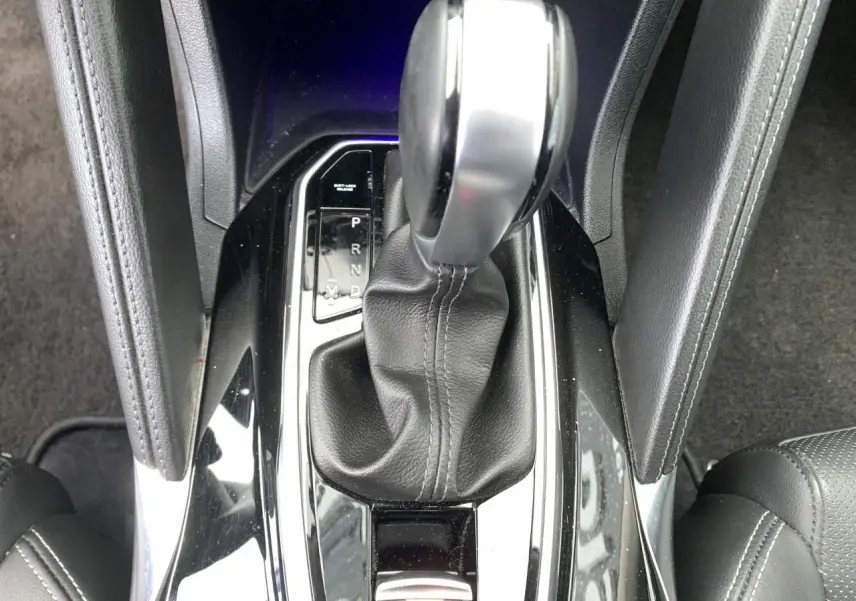 Gros plan sur la console centrale du Renault Koleos 2019, levier de vitesses automatique en cuir noir.