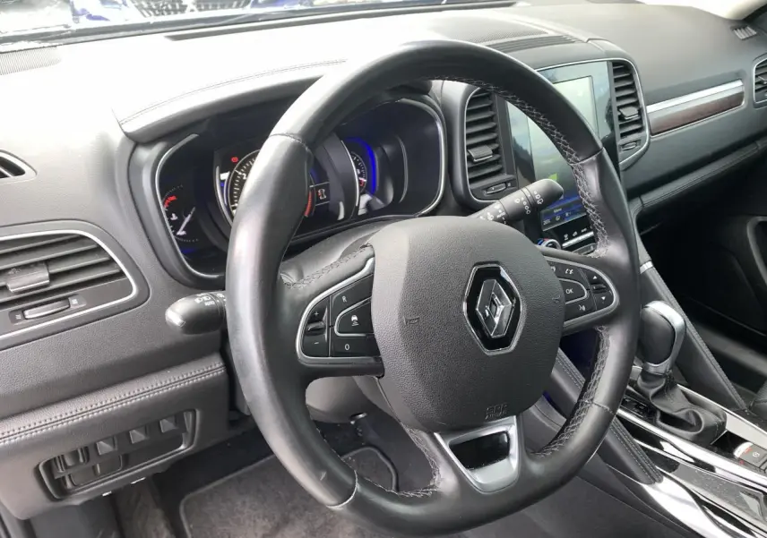 Vue intérieure du volant cuir noir du Renault Koleos 2019 avec tableau de bord et console centrale en noir brillant.