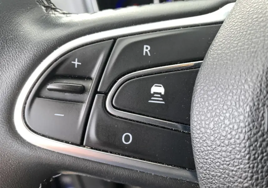 Gros plan sur les commandes noires du volant cuir du Renault Koleos 2019, version Intens, avec contour chromé.