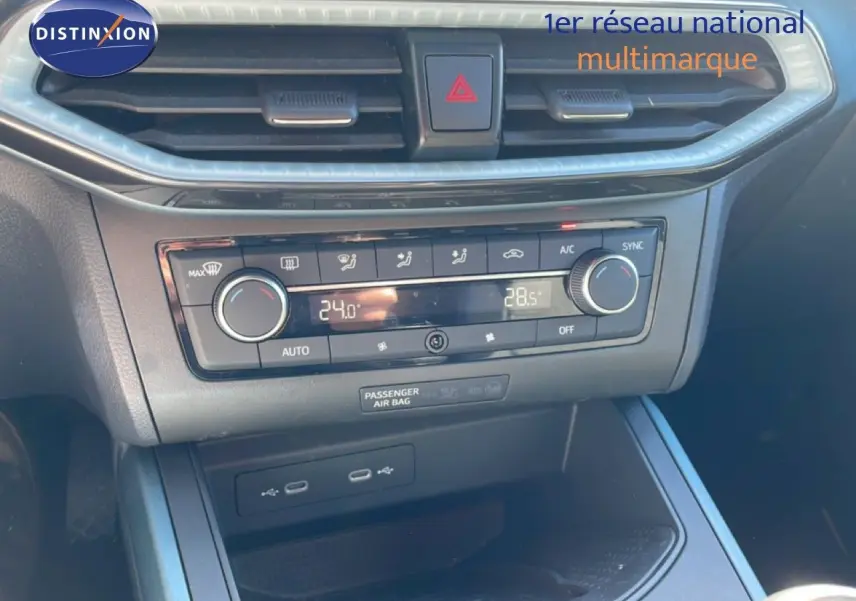 Vue rapprochée de la console centrale du SEAT Arona 2025, avec commandes de climatisation digitale et prises USB visibles.
