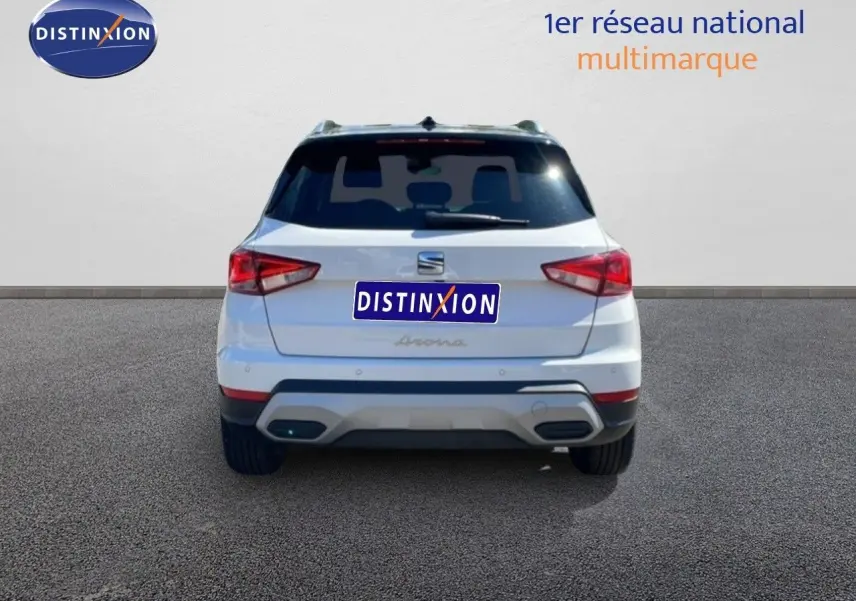 Vue arrière d'un SEAT Arona blanc Nevada avec toit noir, version Style Special Edition 2025, sur sol gris neutre.