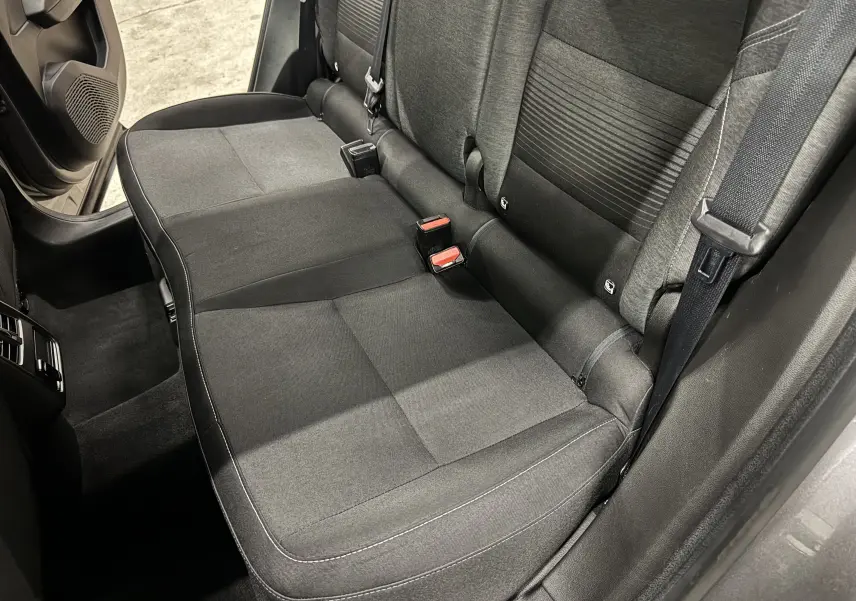 Vue intérieure côté arrière droit du siège arrière gris foncé du Renault Captur TCE 90 CH Business 2021 avec ceintures de sécurité visibles.