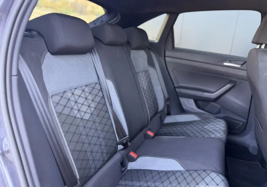 Vue intérieure côté gauche des sièges arrière en tissu noir et gris avec motifs géométriques du Volkswagen Taigo TSI 116 DSG R-Line 2025.