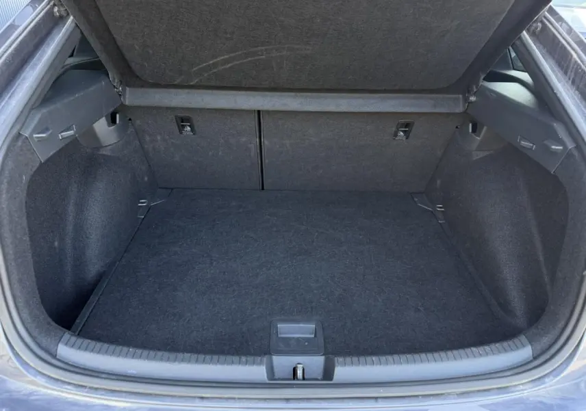 Coffre ouvert vu de face du Volkswagen Taigo gris intense, montrant un espace de chargement propre et spacieux.