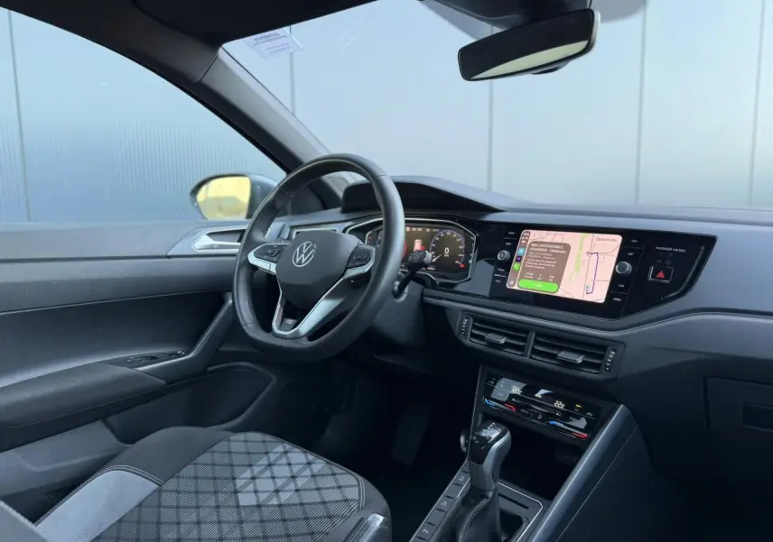 Vue intérieure côté conducteur du Volkswagen Taigo 2025, tableau de bord moderne avec écran tactile et volant multifonctions cuir.
